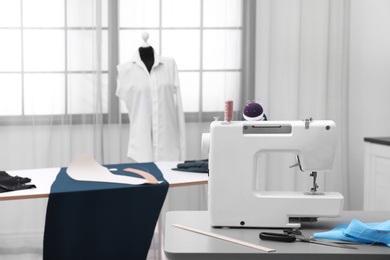 Photo of Tailor workshop interior with sewing machine on table