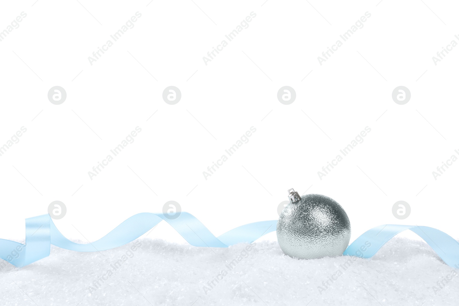 Photo of Beautiful Christmas ball and light blue ribbon on snow against white background