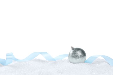 Beautiful Christmas ball and light blue ribbon on snow against white background