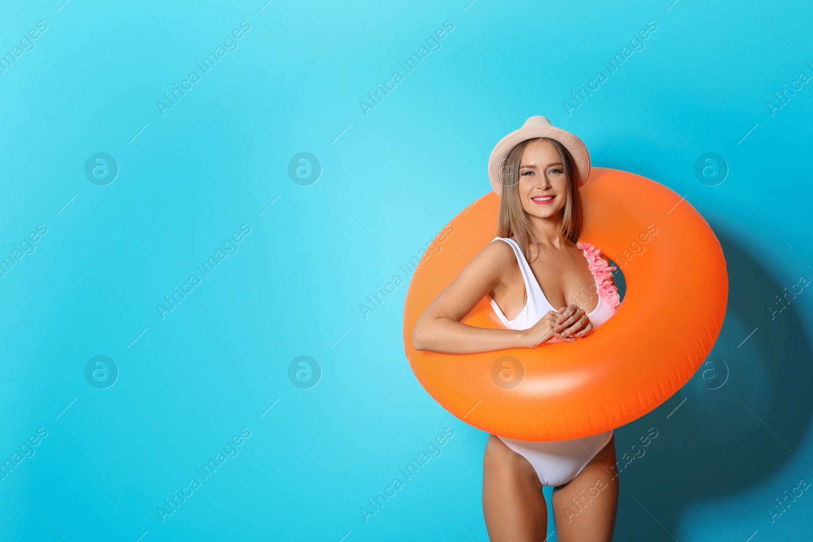 Photo of Sexy young woman in bikini with inflatable ring on color background