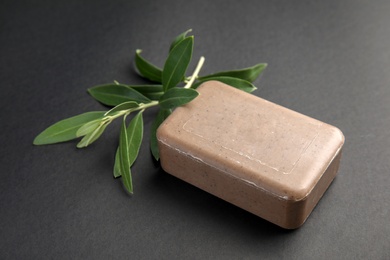 Photo of Olive twig and soap bar on black background