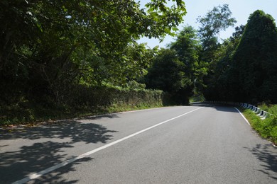 Photo of View of empty asphalted roadway and trees