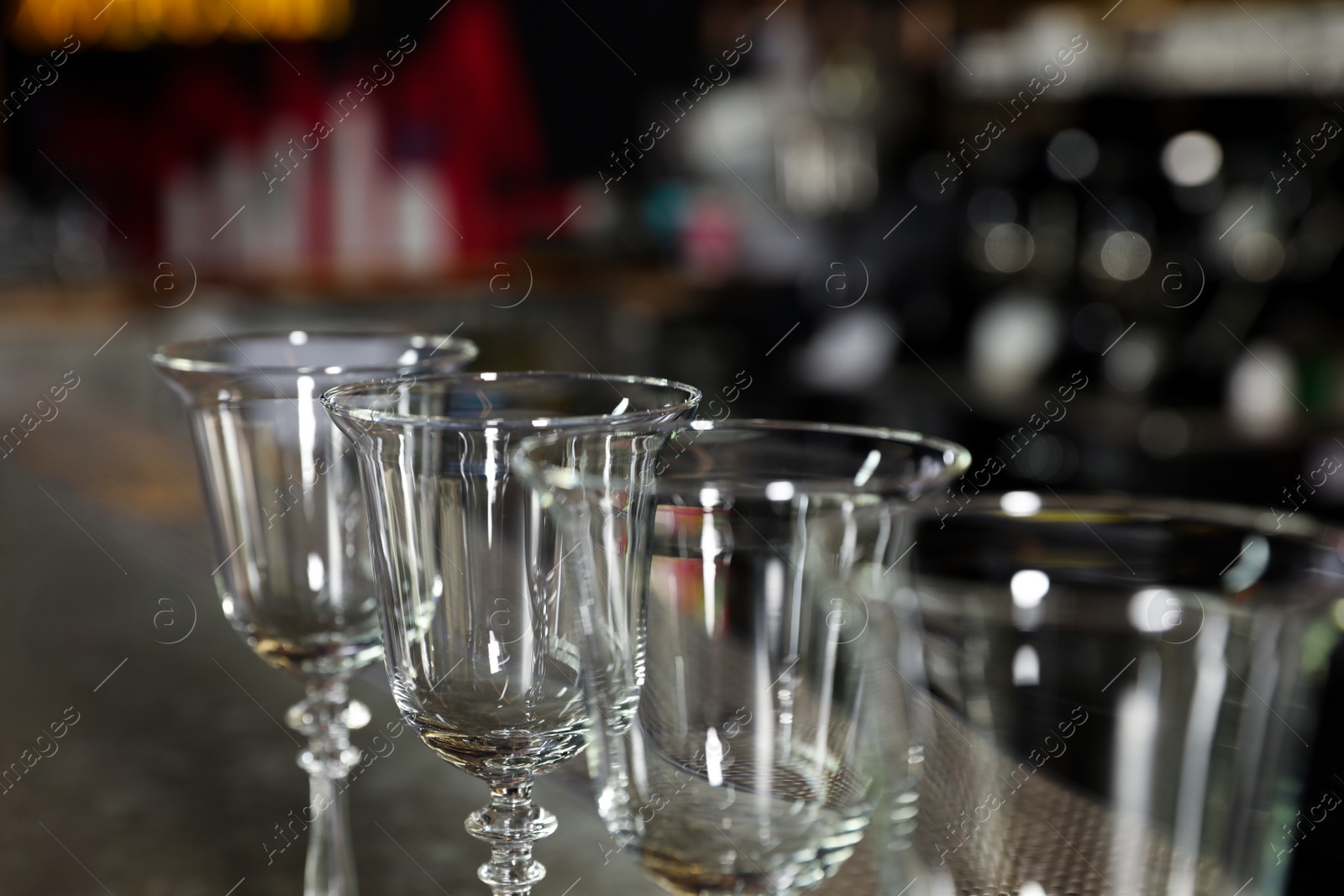 Photo of Row of empty clean glasses on counter in bar, closeup