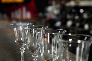 Row of empty clean glasses on counter in bar, closeup