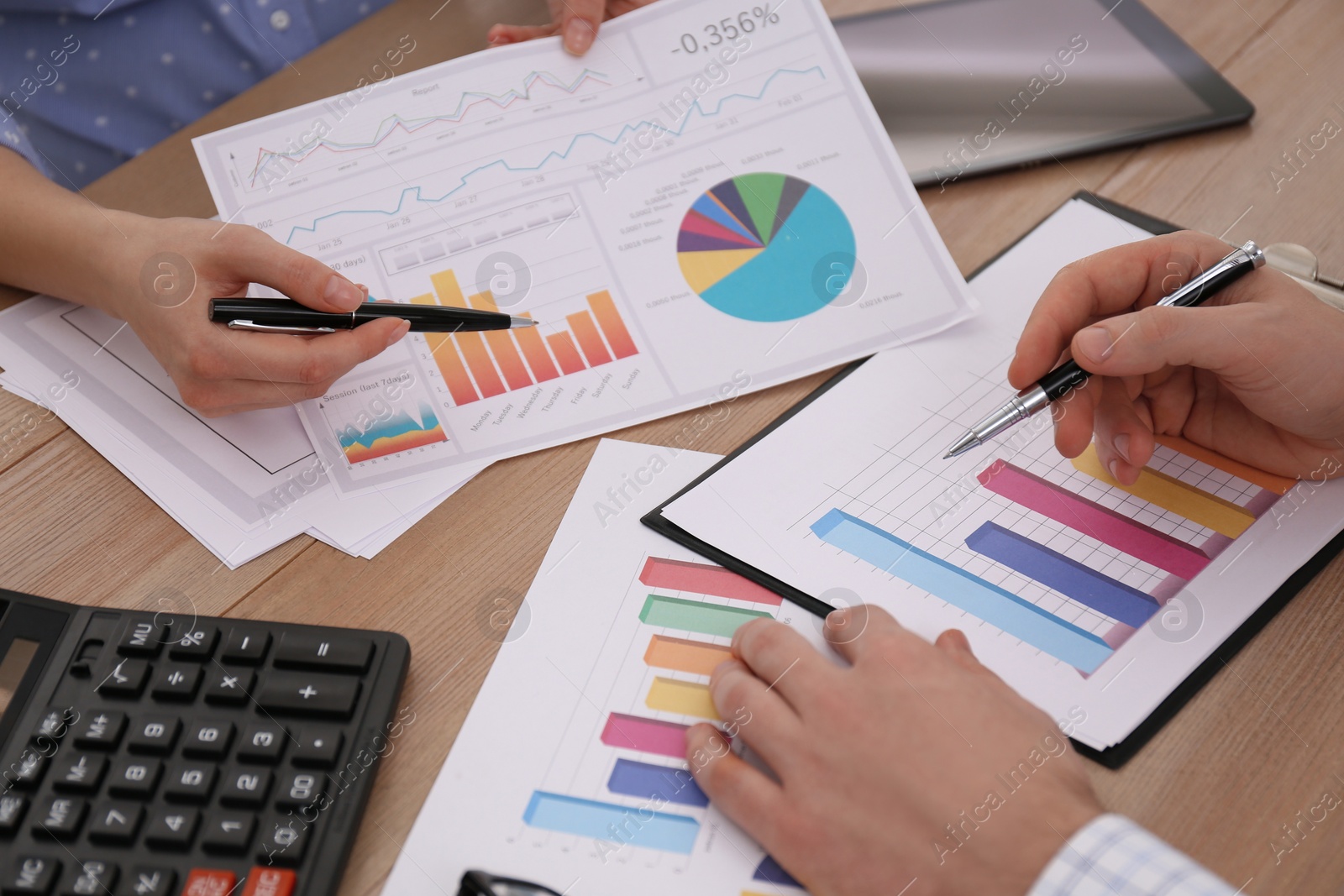 Photo of Business people working with charts and graphs at table in office, closeup. Investment analysis