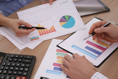 Photo of Business people working with charts and graphs at table in office, closeup. Investment analysis