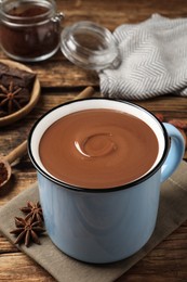 Photo of Yummy hot chocolate in mug on wooden table