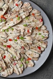 Photo of Tasty pickled anchovies with spices on grey textured table, top view