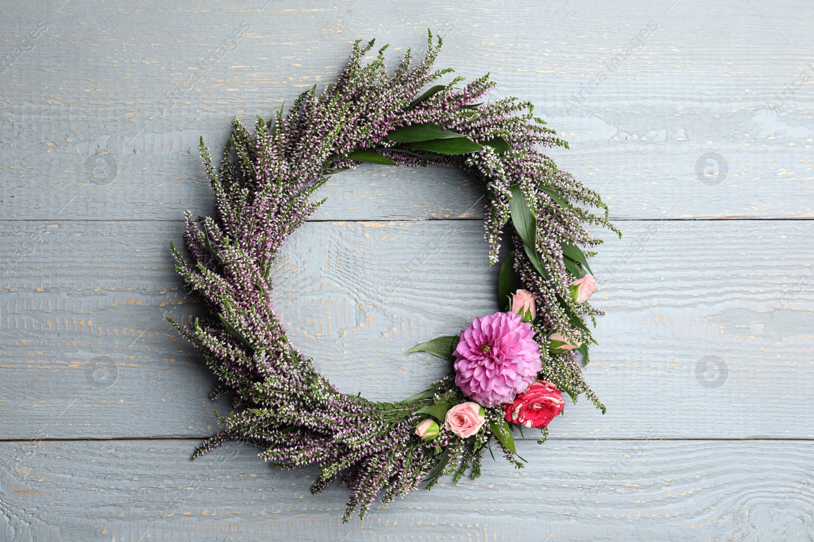 Photo of Beautiful autumnal wreath with heather flowers on light grey wooden background, top view. Space for text