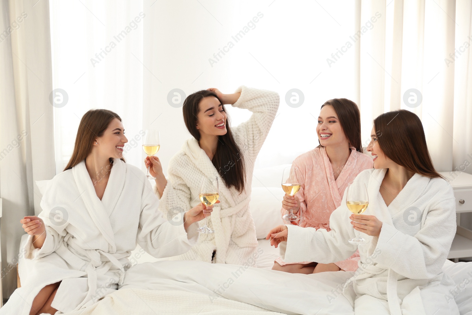 Photo of Beautiful young ladies toasting at pamper party indoors. Woman's Day