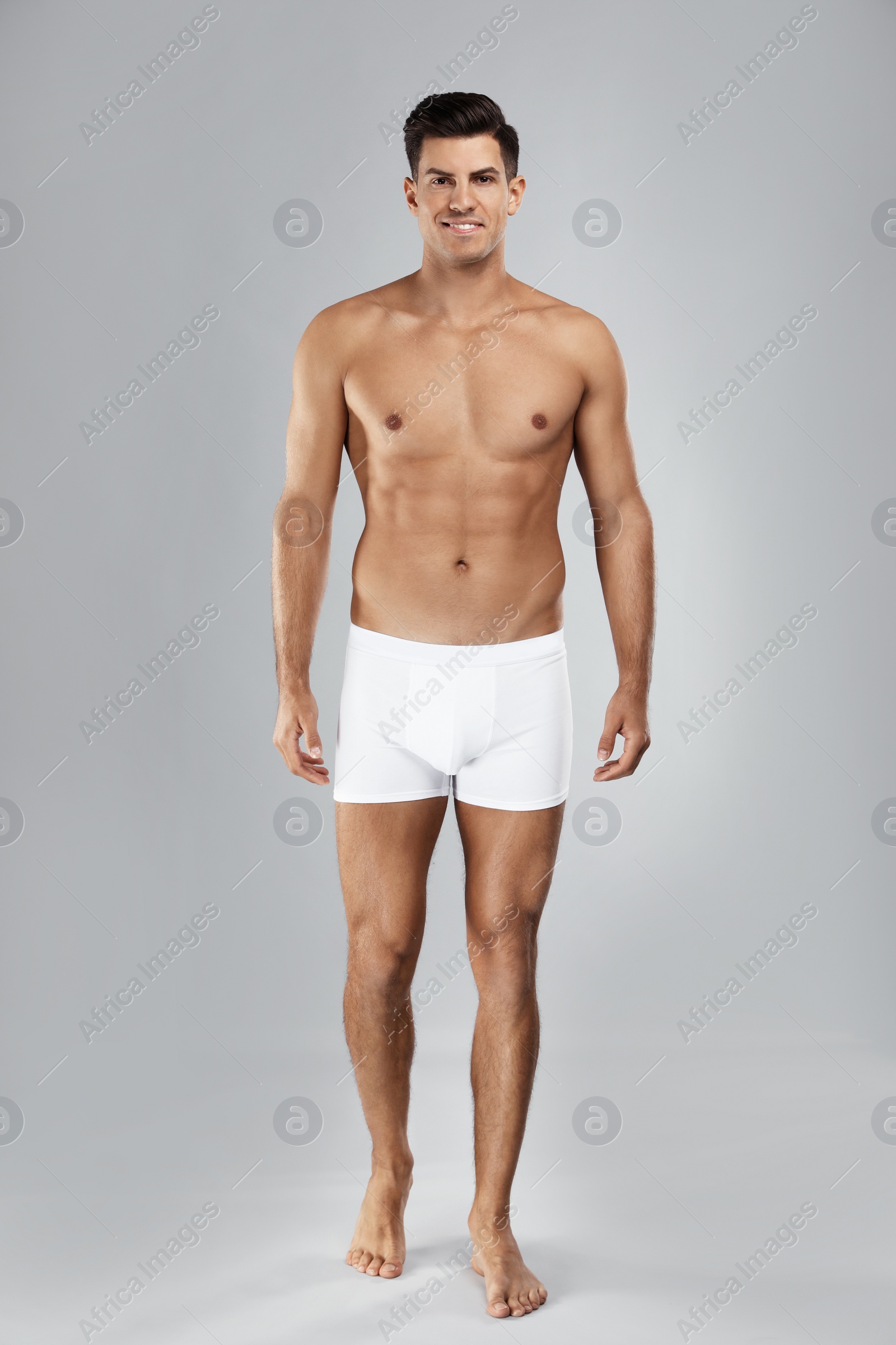 Photo of Handsome man in white underwear on light grey background