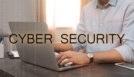 Image of Cyber security concept. Man working with laptop at table indoors, closeup