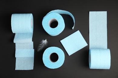 Flat lay composition with toilet paper rolls on black background