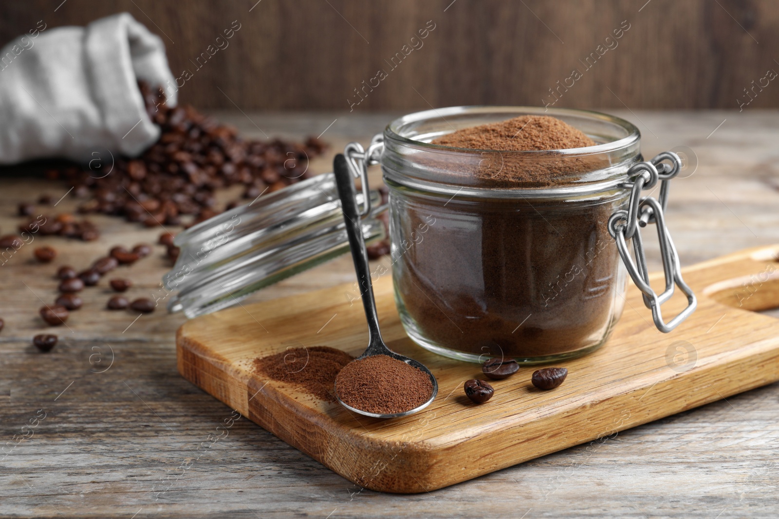 Photo of Glass jar of instant coffee and spoon on wooden table