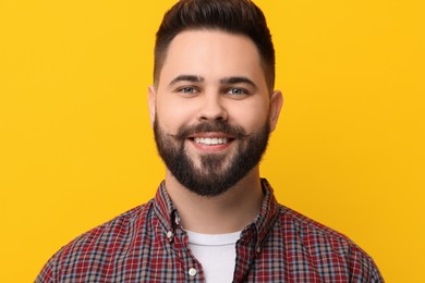 Photo of Portrait of happy young man with mustache on yellow background