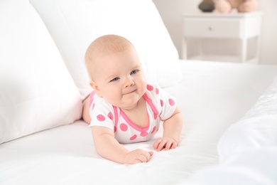 Photo of Cute baby girl on bed at home. Bedtime schedule