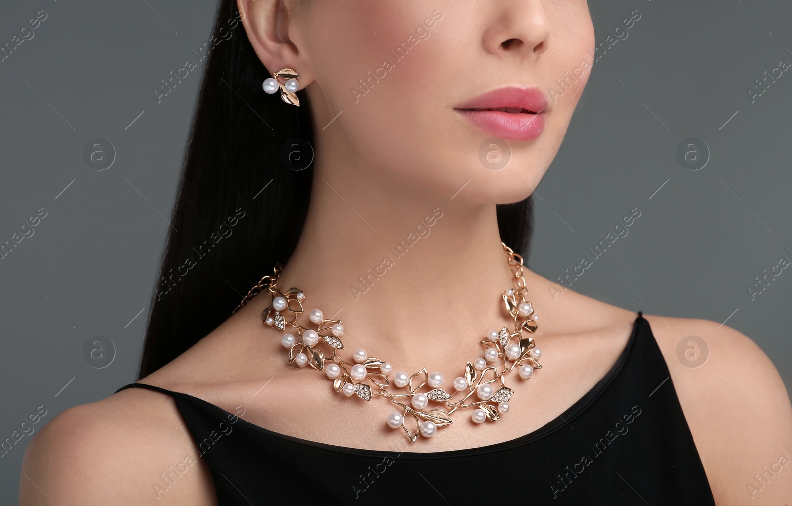 Photo of Young woman with elegant jewelry on dark grey background, closeup