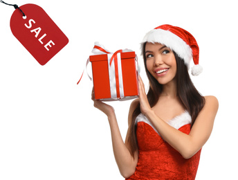 Boxing day. Beautiful Asian woman in Santa costume with Christmas gift and sale tag on white background