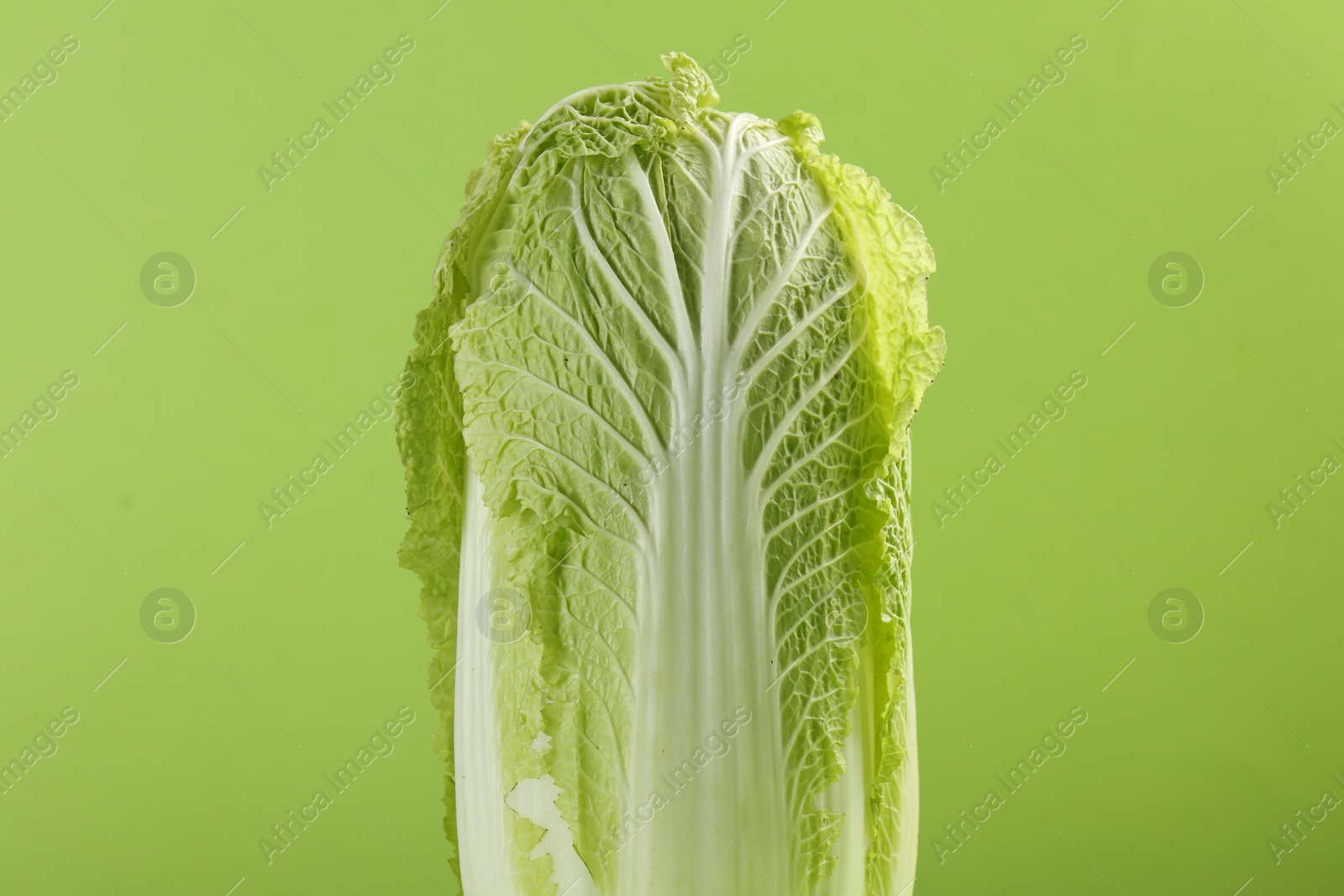 Photo of Fresh ripe Chinese cabbage on light green background, closeup