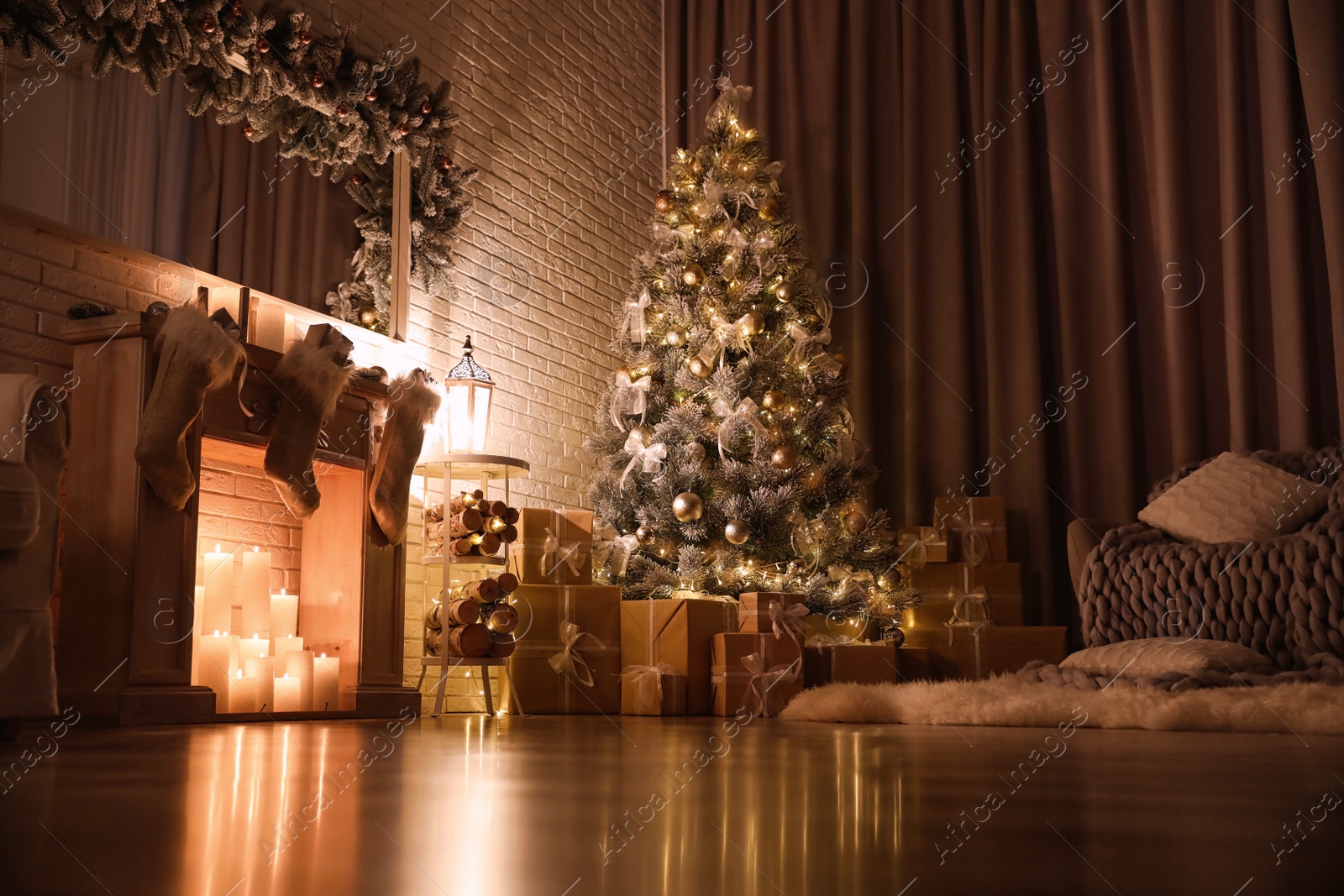 Photo of Stylish interior with beautiful Christmas tree and artificial fireplace at night