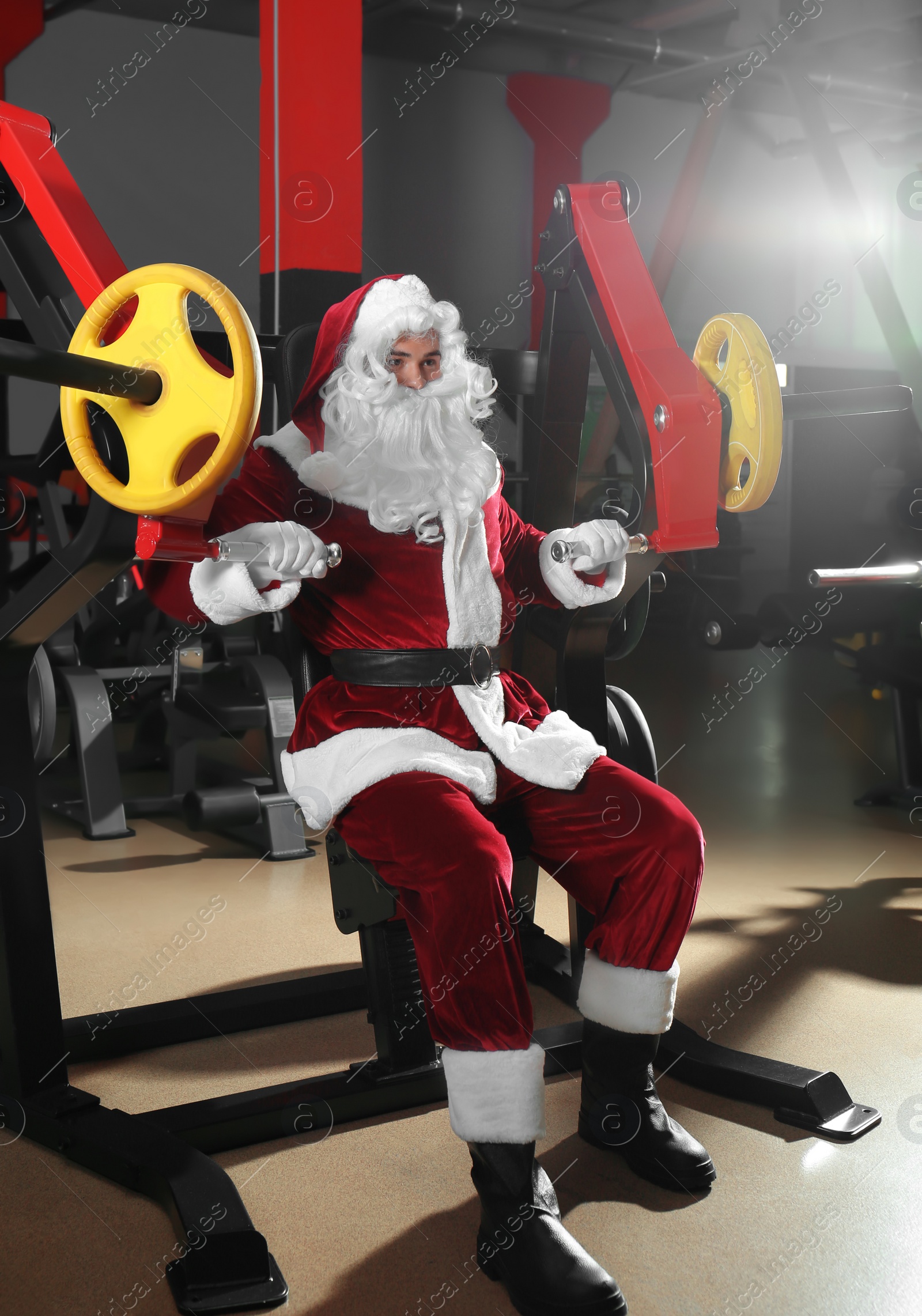 Photo of Young Santa Claus training in modern gym