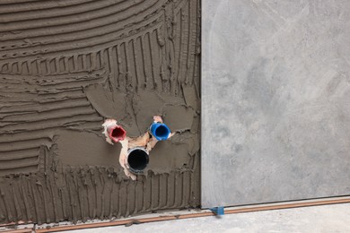 Photo of Adhesive mix and tile on wall indoors