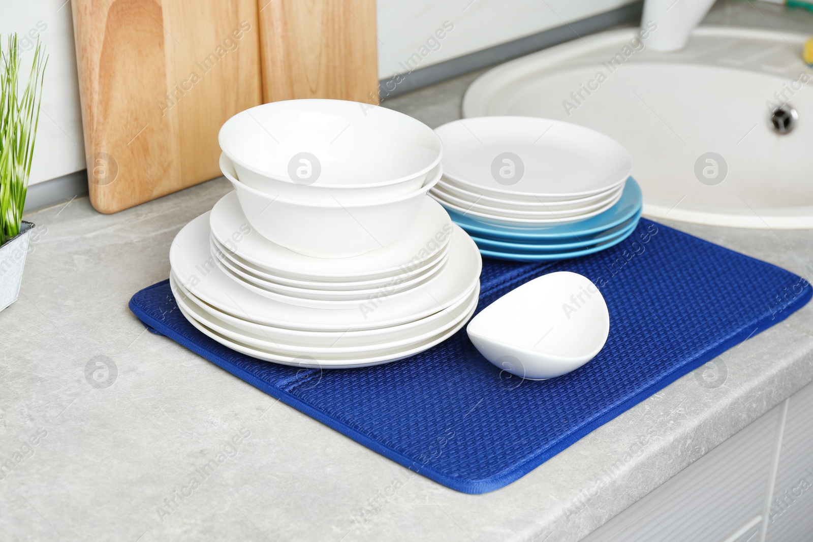 Photo of Different clean plates near sink on kitchen counter