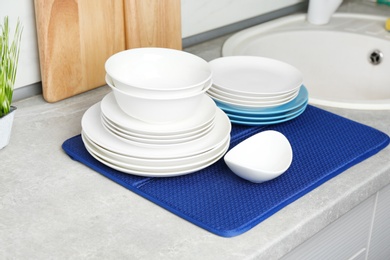 Different clean plates near sink on kitchen counter