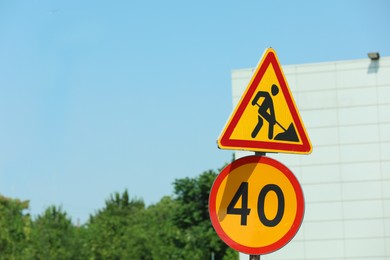 Photo of Road construction and speed limit signs outdoors on sunny day. Repair works