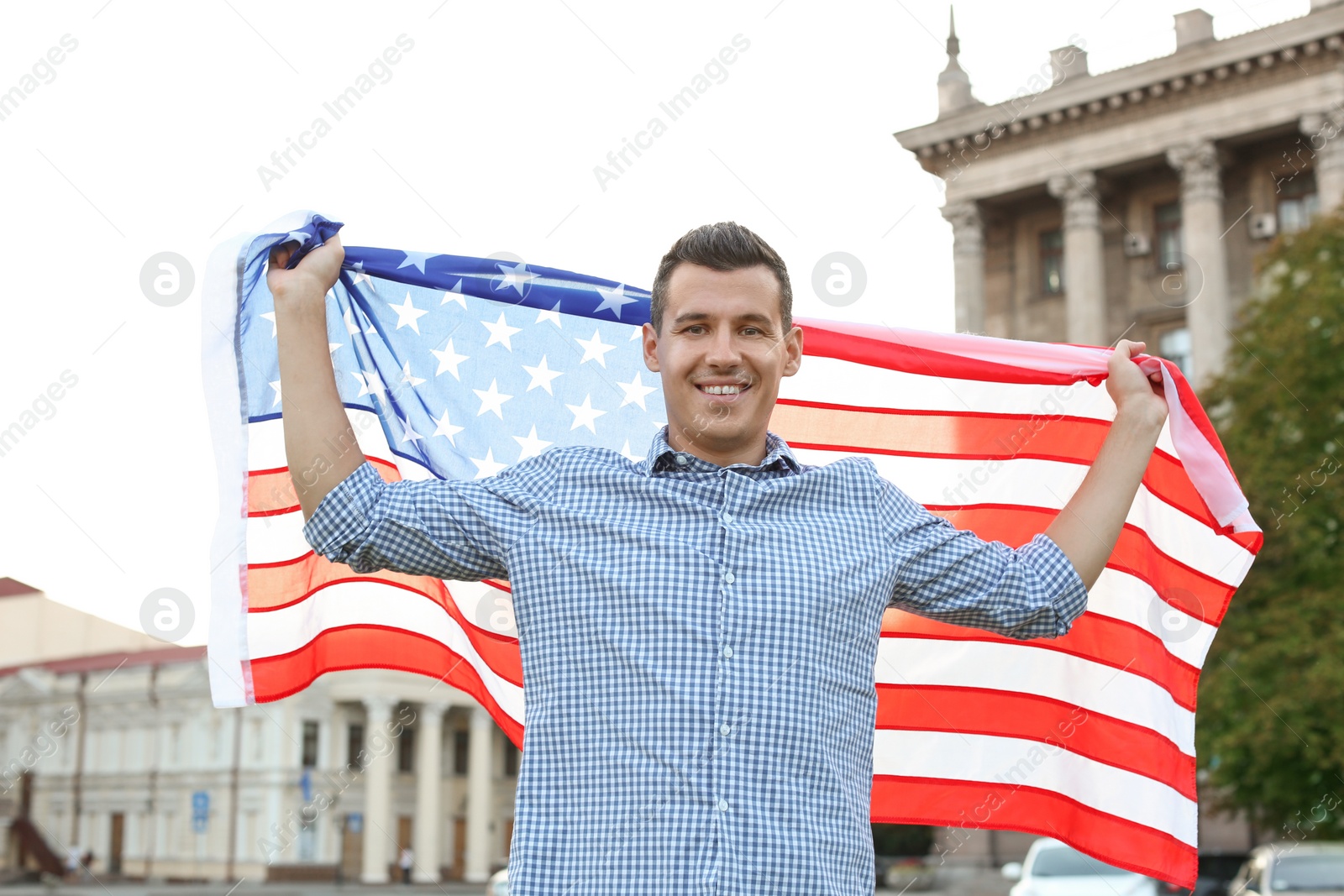 Photo of Man with American flag on city street