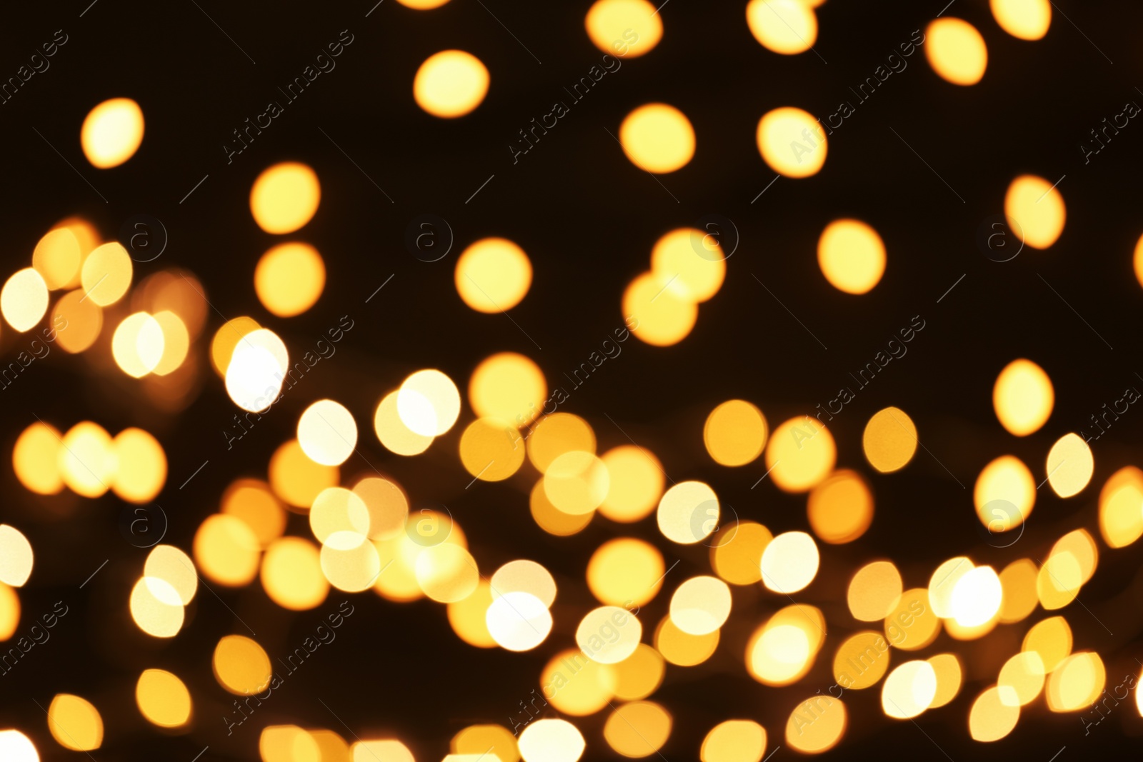 Photo of Beautiful golden lights on dark background. Bokeh effect