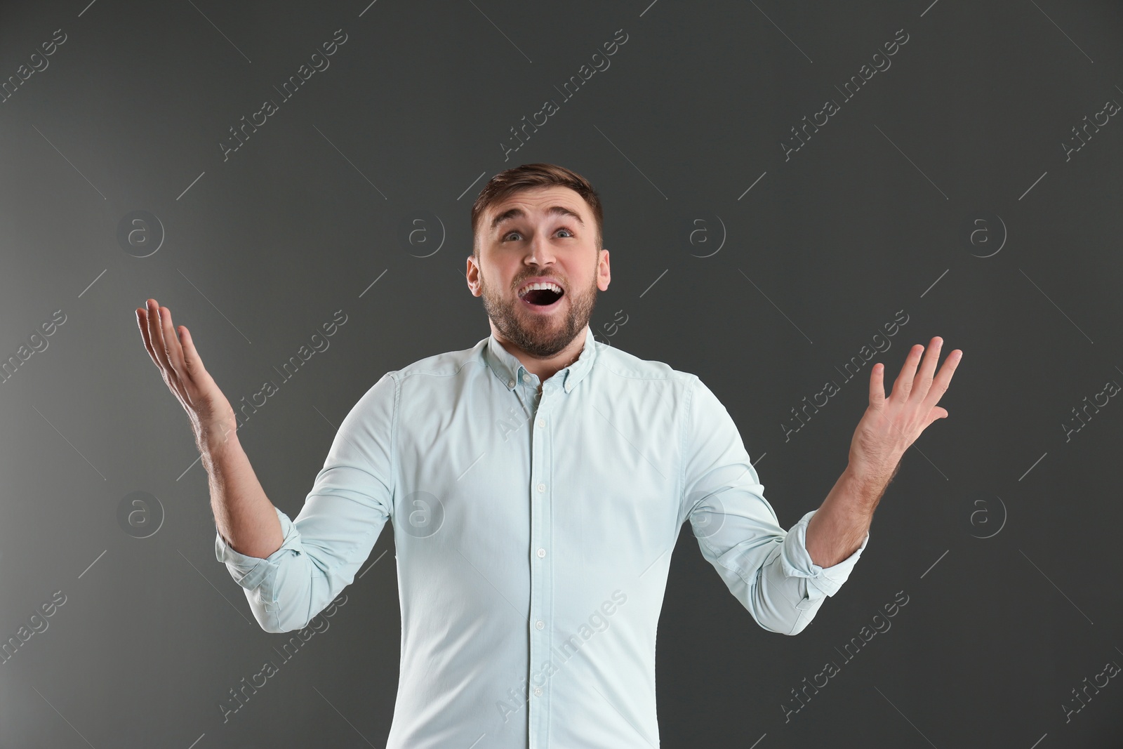 Photo of Portrait of emotional young man on grey background