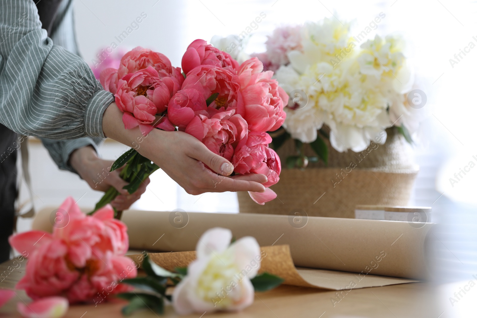 Photo of Florist making beautiful peony bouquet at table, closeup