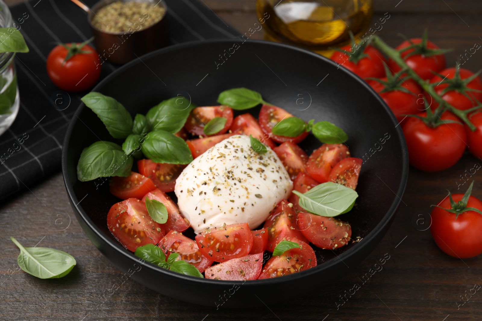 Photo of Tasty salad Caprese with mozarella, tomatoes and basil on wooden table