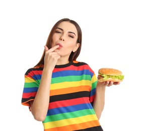 Photo of Young woman eating tasty burger on white background