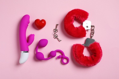 Photo of Different sex toys on pink background, flat lay