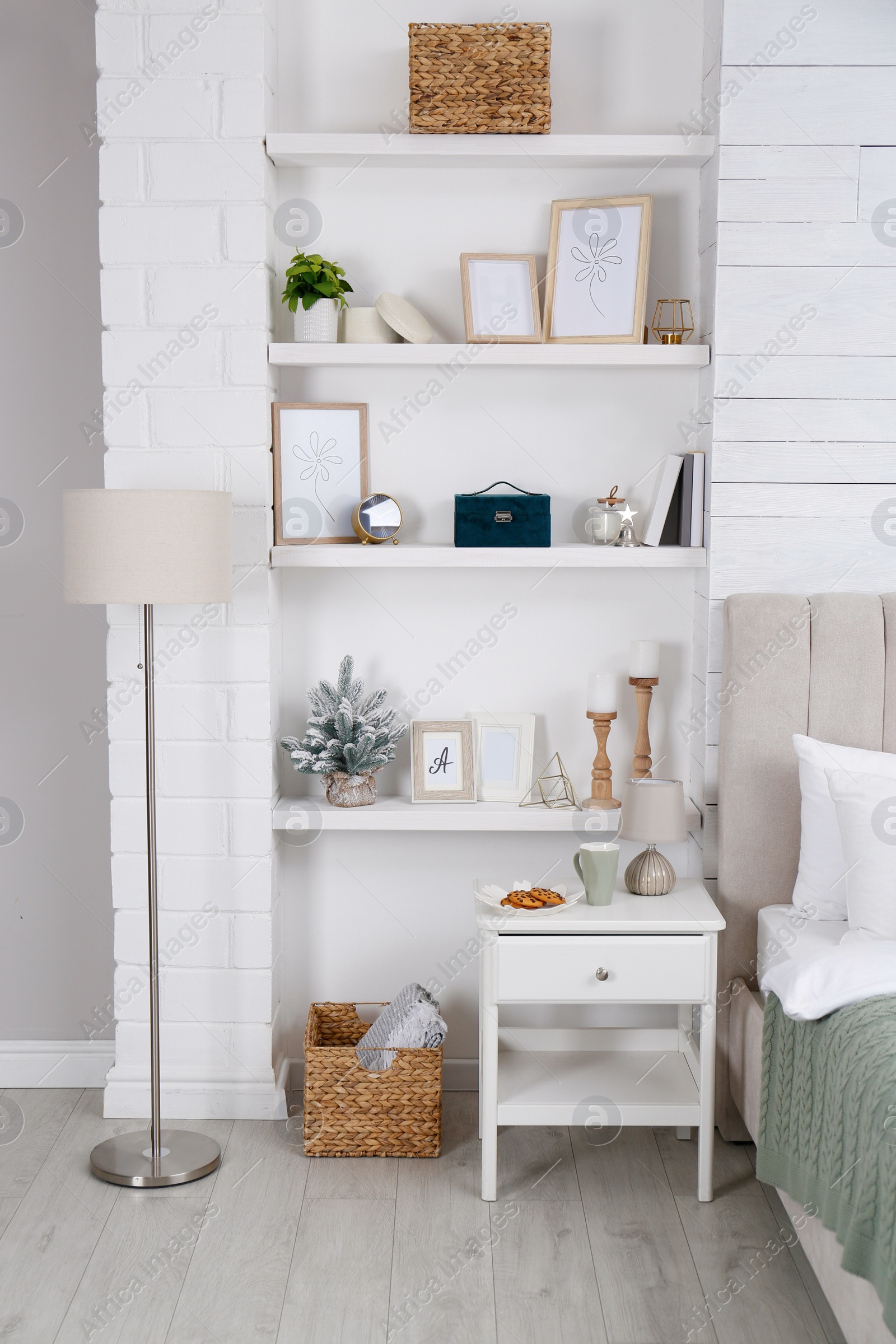 Photo of Wall shelves with beautiful decor elements in stylish bedroom interior