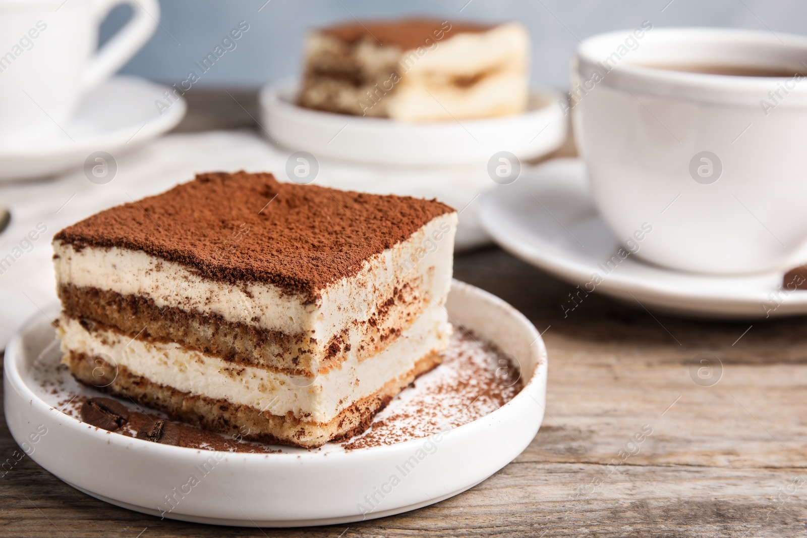 Photo of Composition with tiramisu cake and tea on table, closeup. Space for text