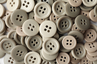 Photo of Many plastic sewing buttons as background, closeup