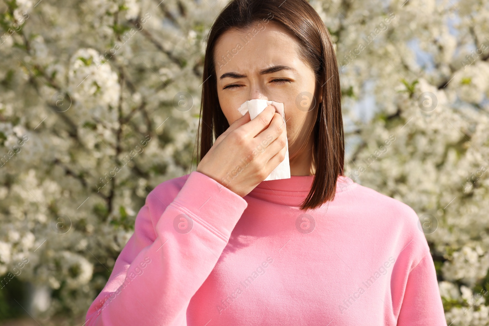 Photo of Woman with napkin suffering from seasonal allergy on spring day