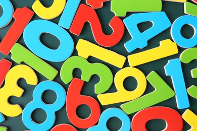 Colorful numbers on green background, top view