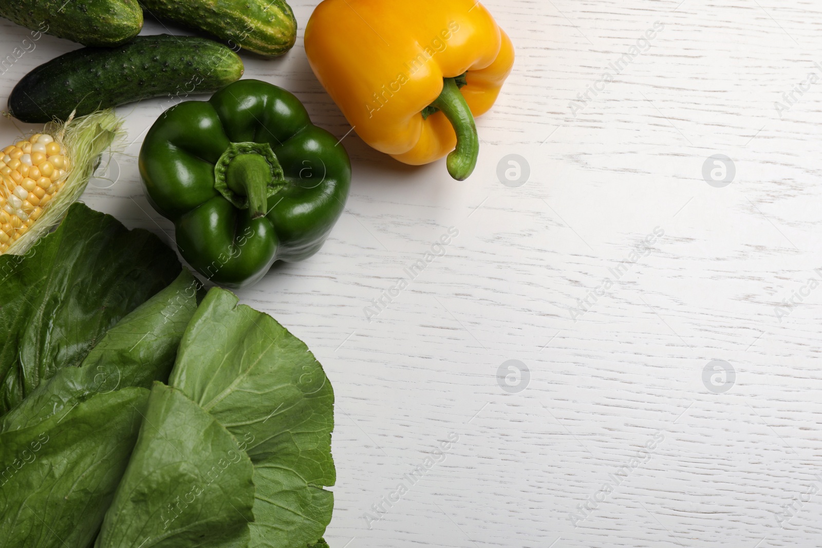 Photo of Different fresh vegetables on white wooden table, flat lay. Space for text