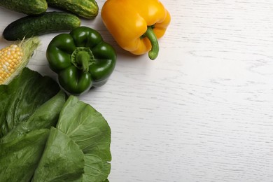 Photo of Different fresh vegetables on white wooden table, flat lay. Space for text