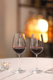 Photo of Glasses of wine for romantic dinner on table in restaurant