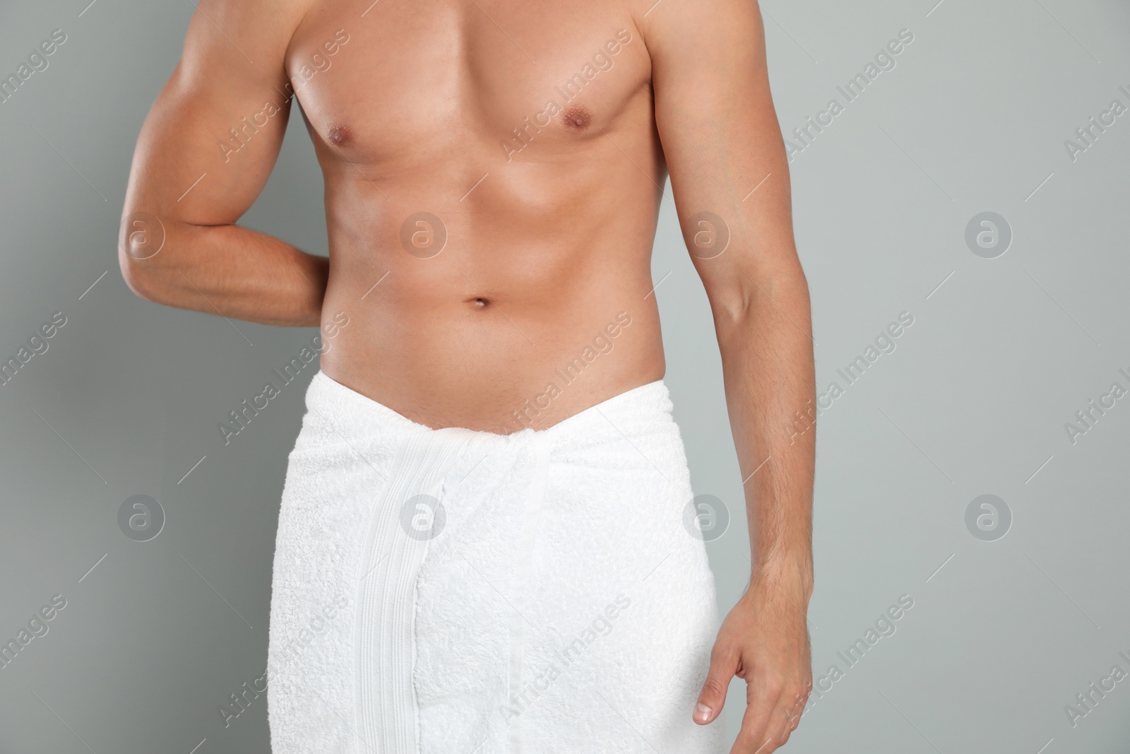 Photo of Young man with slim body on grey background, closeup view