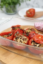 Photo of Delicious stuffed tomatoes with minced beef, bulgur and mushrooms in glass baking dish, closeup