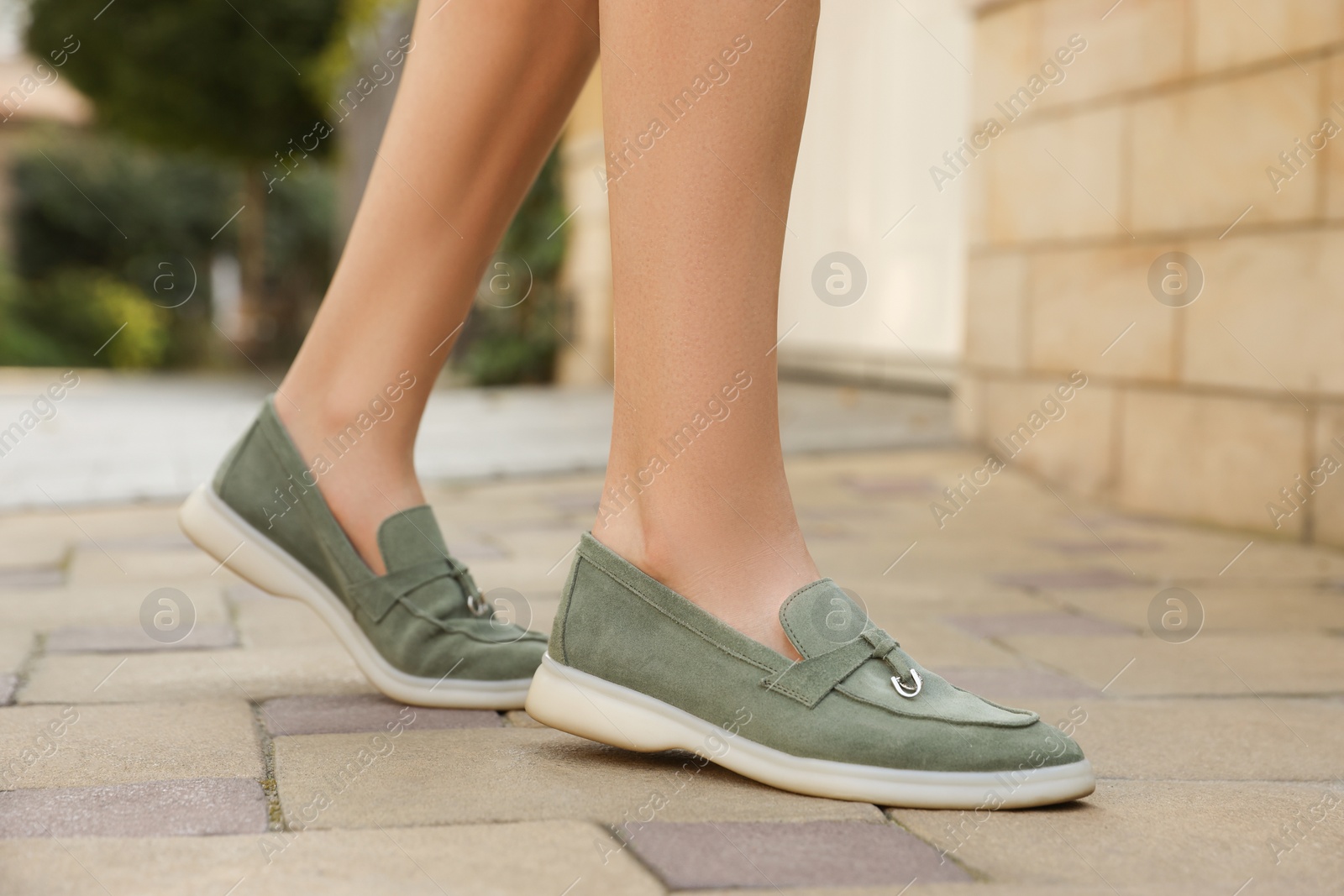 Photo of Woman in stylish loafers walking on city street, closeup