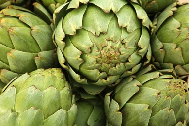 Many fresh raw artichokes as background, top view