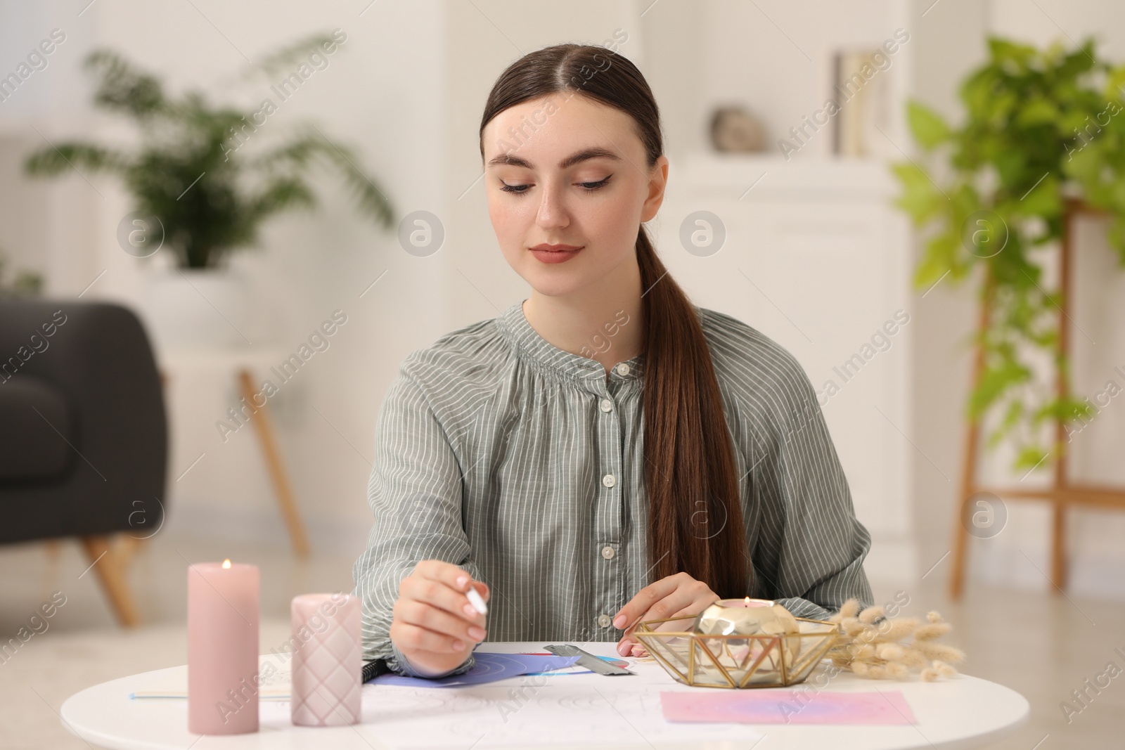 Photo of Astrologer making forecast of fate at table indoors. Fortune telling