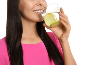 Photo of Young woman drinking tasty lemon water on white background, closeup